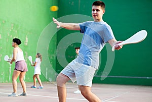 Young man playing Basque pelota on outdoor pelota court photo