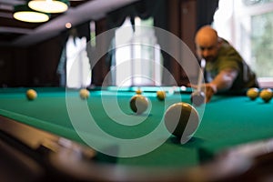 Young man playing billiard indoors. Spending free time on gambling