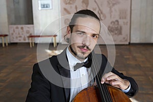 Young man playing the cello. Portrait of the cellist