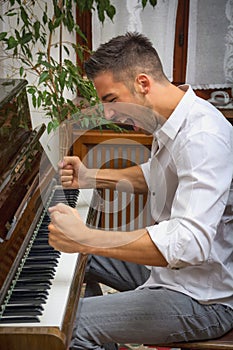 Young man playing classical piano, shouting