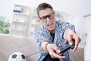 The young man playing computer games at home