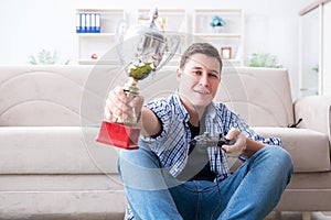 The young man playing computer games at home