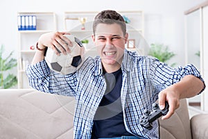 The young man playing computer games at home