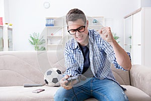 The young man playing computer games at home