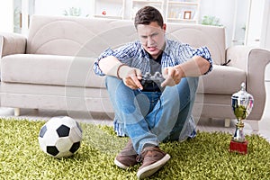 The young man playing computer games at home