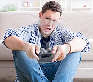 Young man playing computer games at home