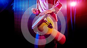 Young man playing on djembe in sound recording studio.