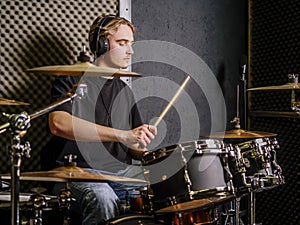 Young man playing drums in a recording studio