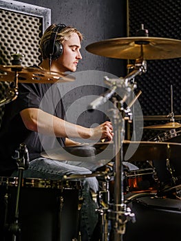 Young man playing drums in a recording studio
