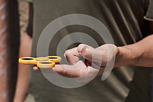 Young man playing with a fidget spinner