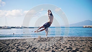 A young man playing frisbee by the sea with his girlfriend.