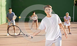 Young man playing frontenis on outdoor pelota court photo