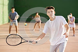 Young man playing frontenis on outdoor pelota court photo