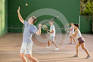 Young man playing frontenis on outdoor pelota court photo
