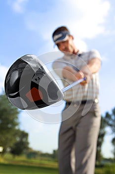 Young man playing golf, low angle view