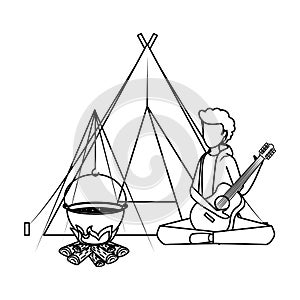 young man playing guitar with camping tent and woodfire