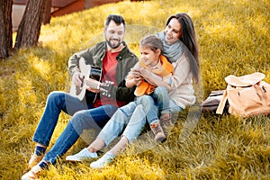 Young man playing guitar with family