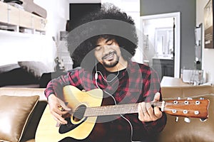 Young man playing guitar at home