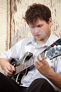 Young man playing guitar outdoors