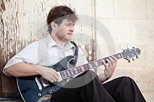 Young man playing guitar outdoors