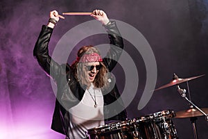 Young man playing hard rock music with drums set