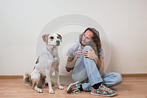 Young man is playing with his dog at home.