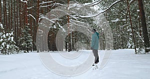 a young man playing with his dog using a flying saucer in a winter snowy forest