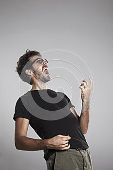 Young man playing imaginary guitar and squealing