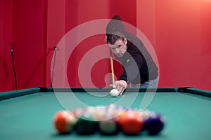 Young man is playing pool