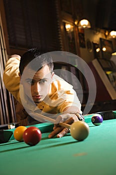 Young man playing pool.