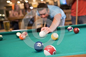 Young man playing pool in a bar