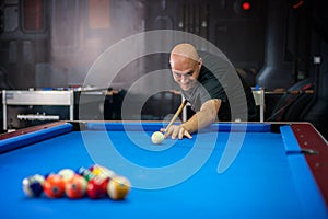 Young man playing pool game in pub