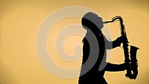 Young man playing sax in the dark