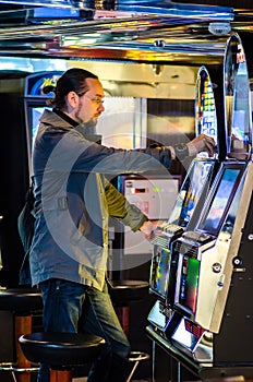 Young man playing at slot machines