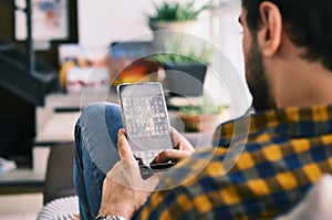 Young Man Playing Sudoku Game With App On Smartphone