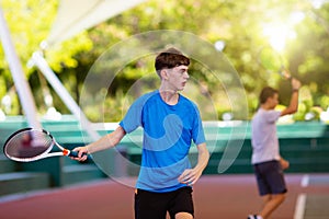 Young man playing tennis on open court