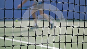 Young man playing Tennis with tennis Racket on a sunny day. slow motion. blurred on grid foreground. 1920x1080