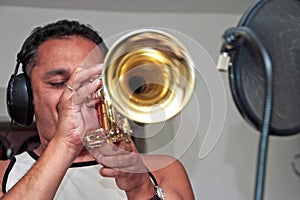 Young man playing trumpet in studio