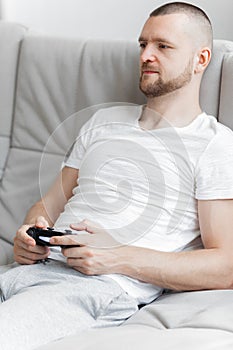 Young man playing tv console on sofa