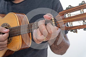 Young man playing ukulele with shirt and black pants photo