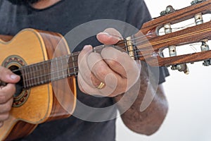 Young man playing ukulele with shirt and black pants photo