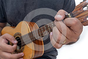 Young man playing ukulele with shirt and black pants photo