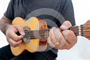 Young man playing ukulele with shirt and black pants photo