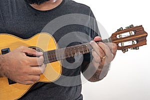 Young man playing ukulele with shirt and black pants photo