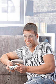 Young man playing video game at home