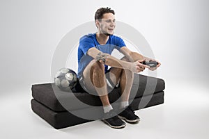 Young man playing video games in black shirt isolated studio