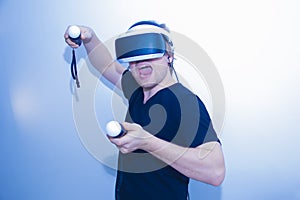 A young man is playing VR. The joysticks. White background. Image of a happy bearded young man in a virtual reality