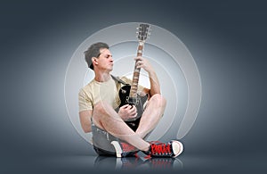 Young man plays the electric guitar