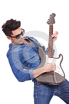Young man plays electric guitar