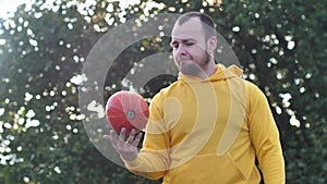 a young man plays with a pumpkin as a ball.Traditional symbol of Halloween